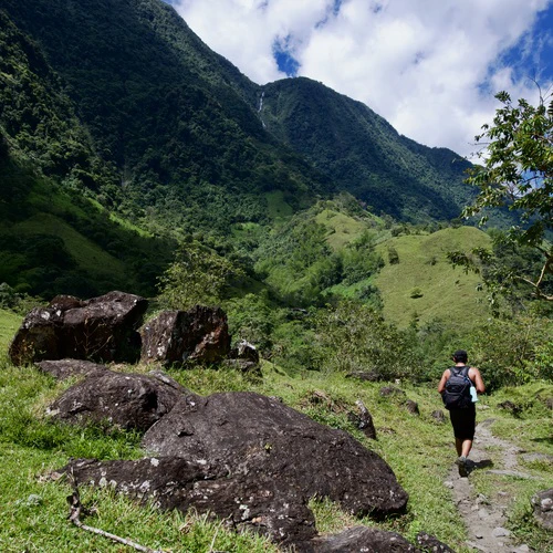 hiker in the sunny valle de las cascadas surrounded by mountains in the distance