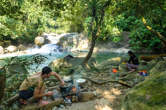 Guide cooking food on a wild camp in the jungle by the Samana river.